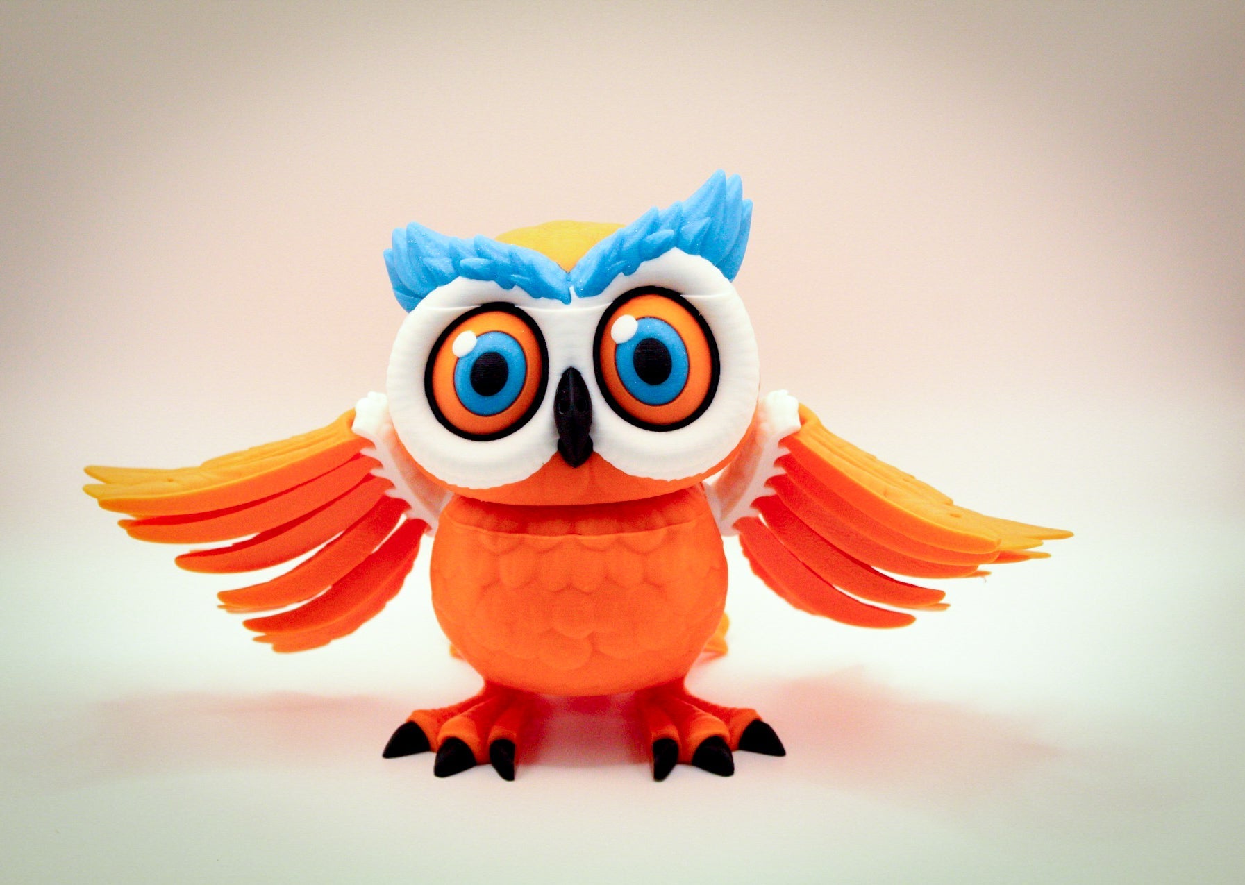 Articulated 3D printed owl toy with colorful features and articulated wings, perfect for posing and play.