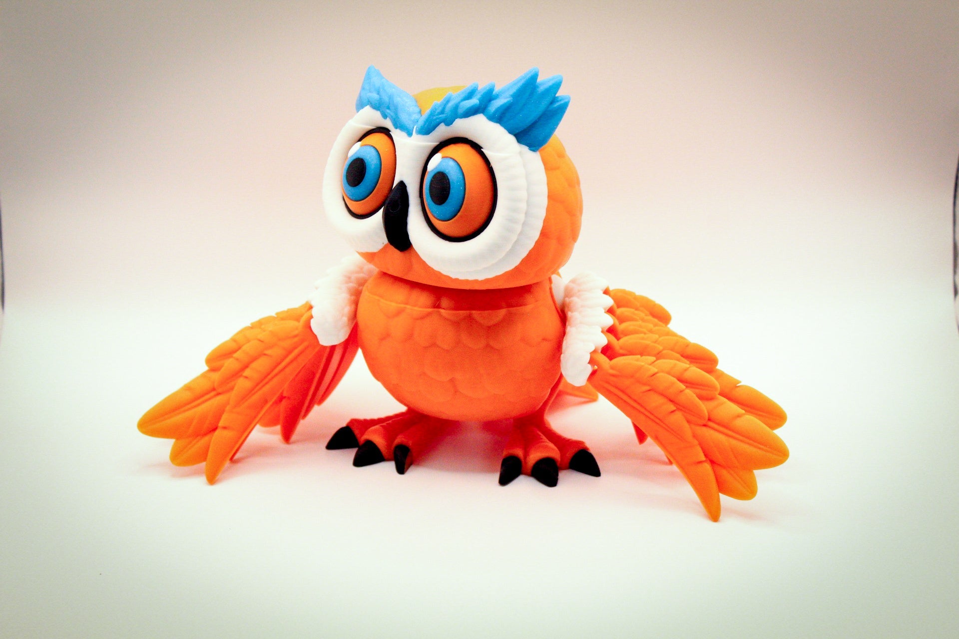 Articulated 3D printed owl toy showcasing vibrant colors and flexible, poseable wings.