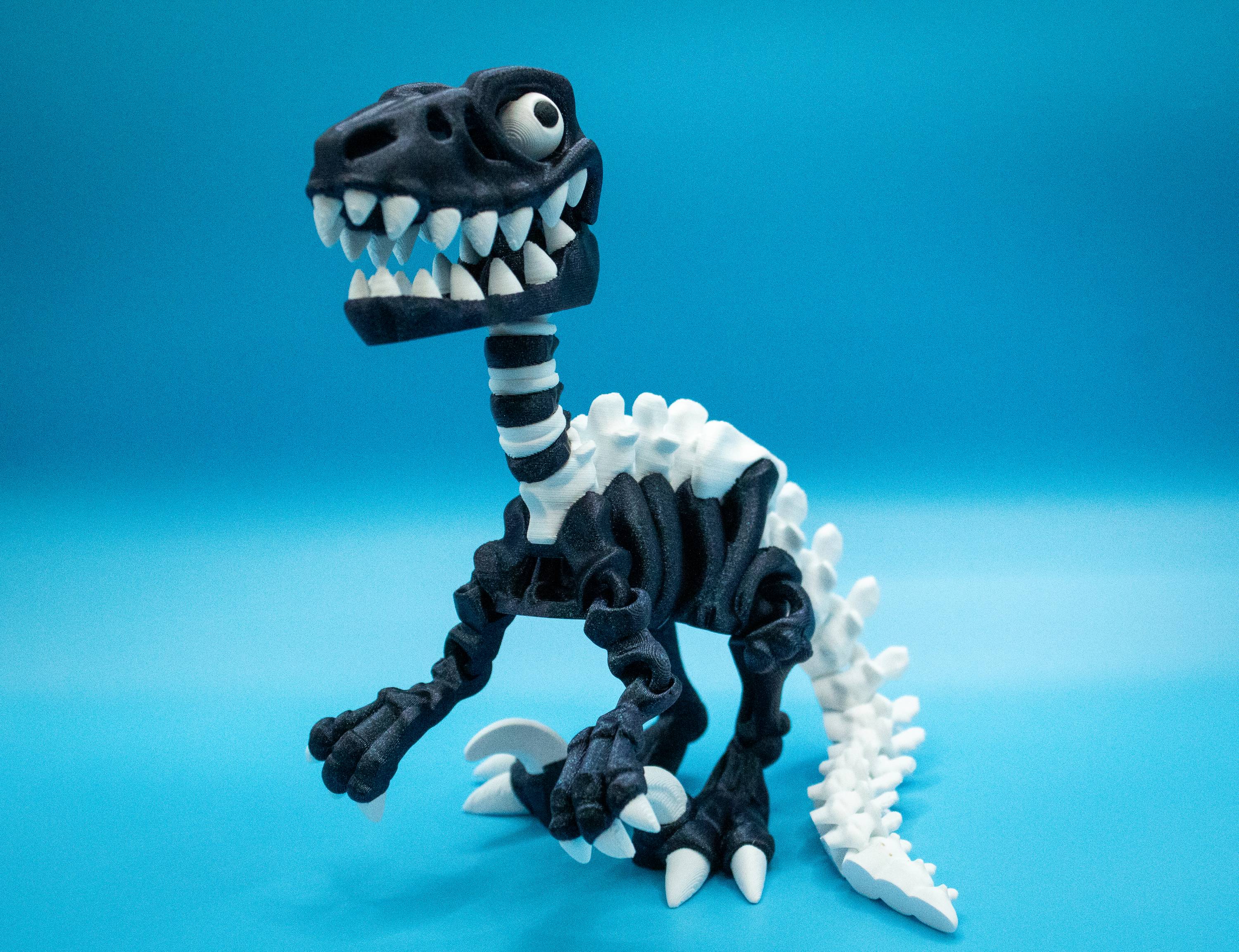 3D-printed Velociraptor collectible featured in dynamic pose against a blue background.